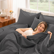 A woman is lying on a bed make with percale sheets and pillowcases