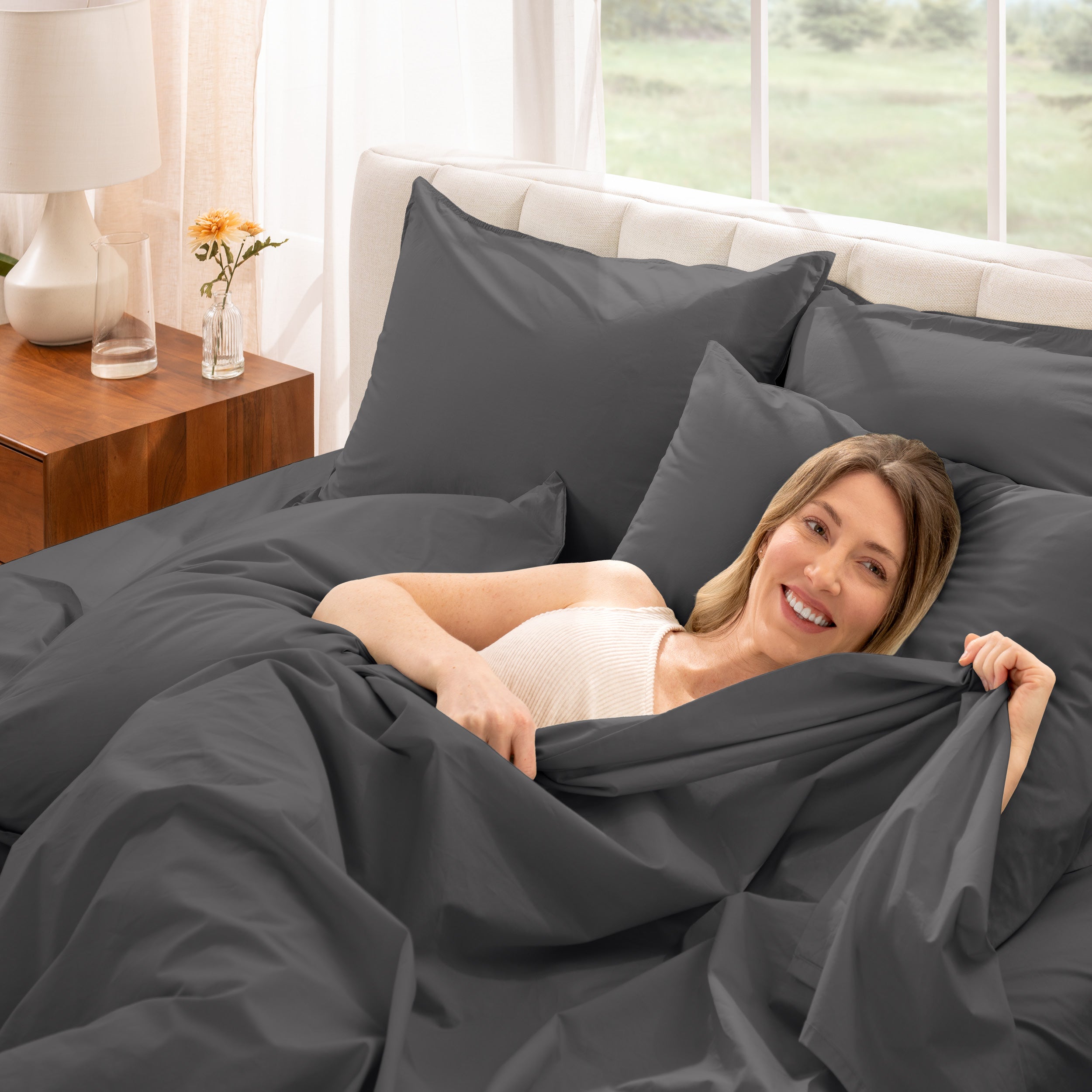 A woman is lying on a bed make with percale sheets and pillowcases