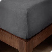 A corner of a modern bed with a polar fleece fitted sheet on.