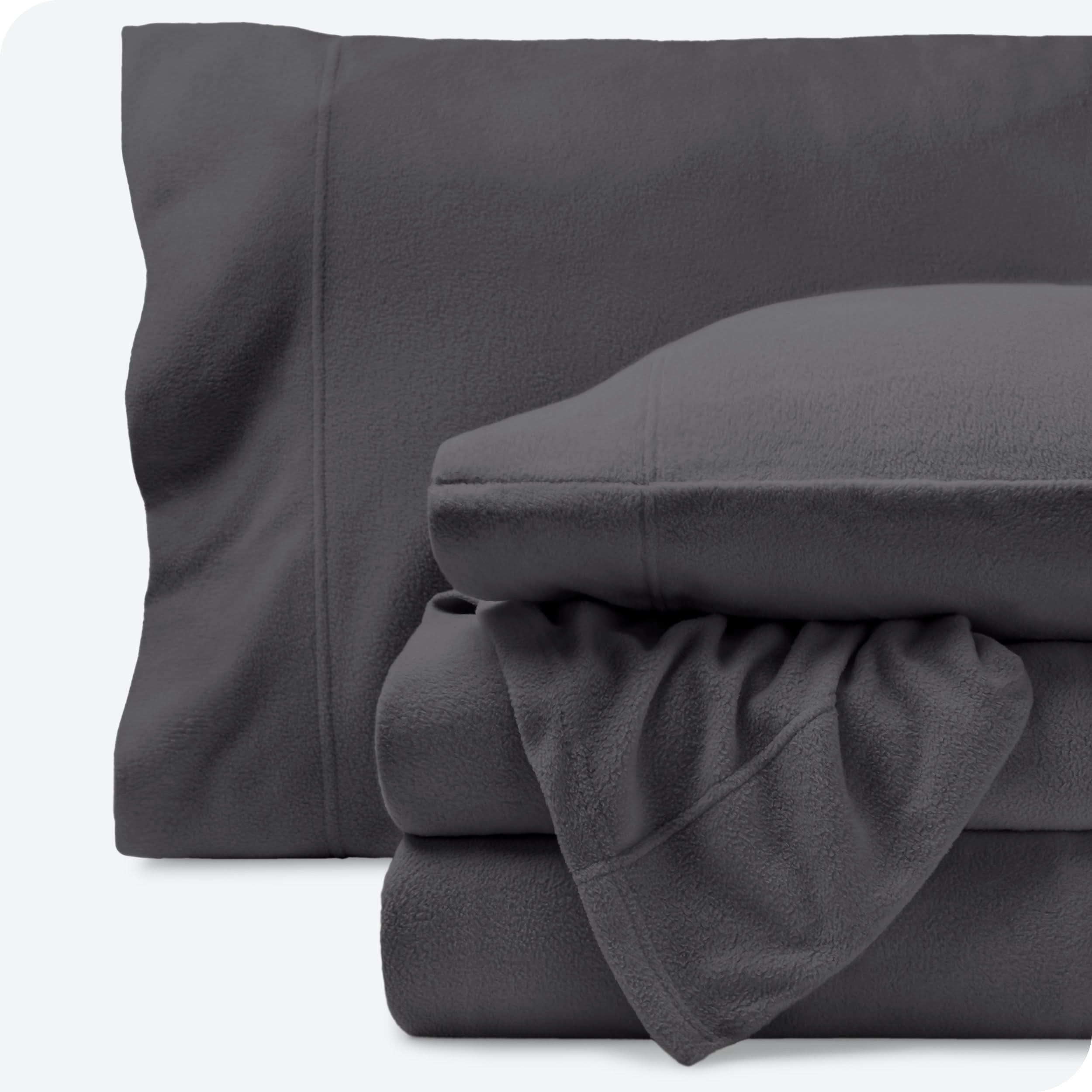 Fleece sheets folded neatly and stacked with pillows inside the pillowcases