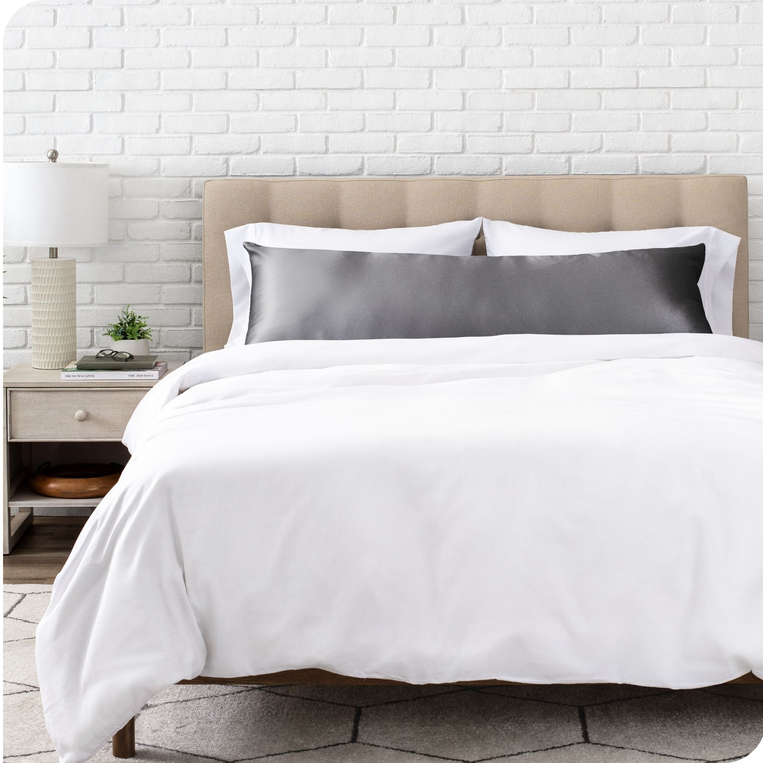 A satin body pillowcase on a bed with white linens