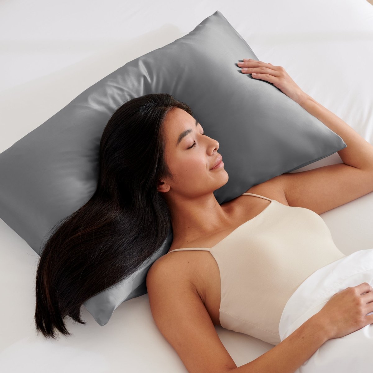 Woman lying on a bed with a pillow covered with a satin pillowcase