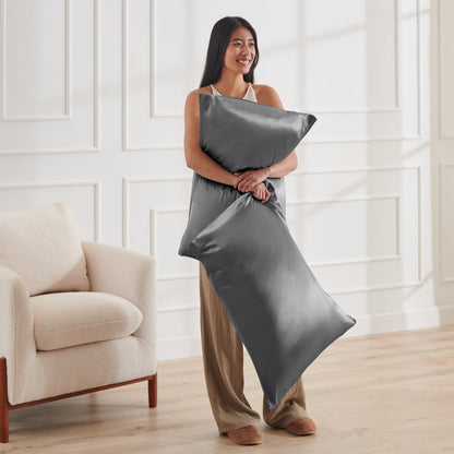 Woman holding 2 pillows with satin pillowcases on them