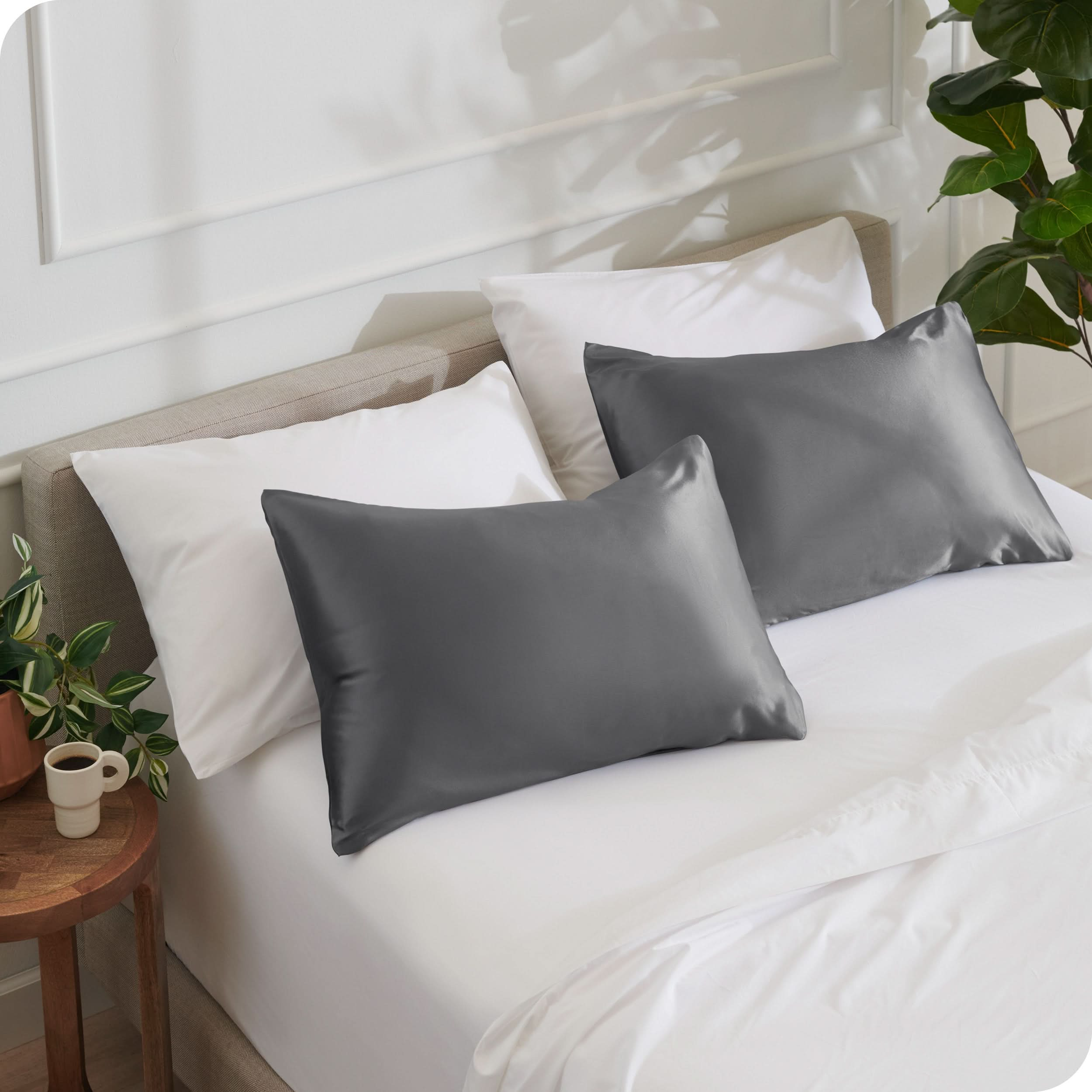 2 satin pillowcases on pillows set on a bed