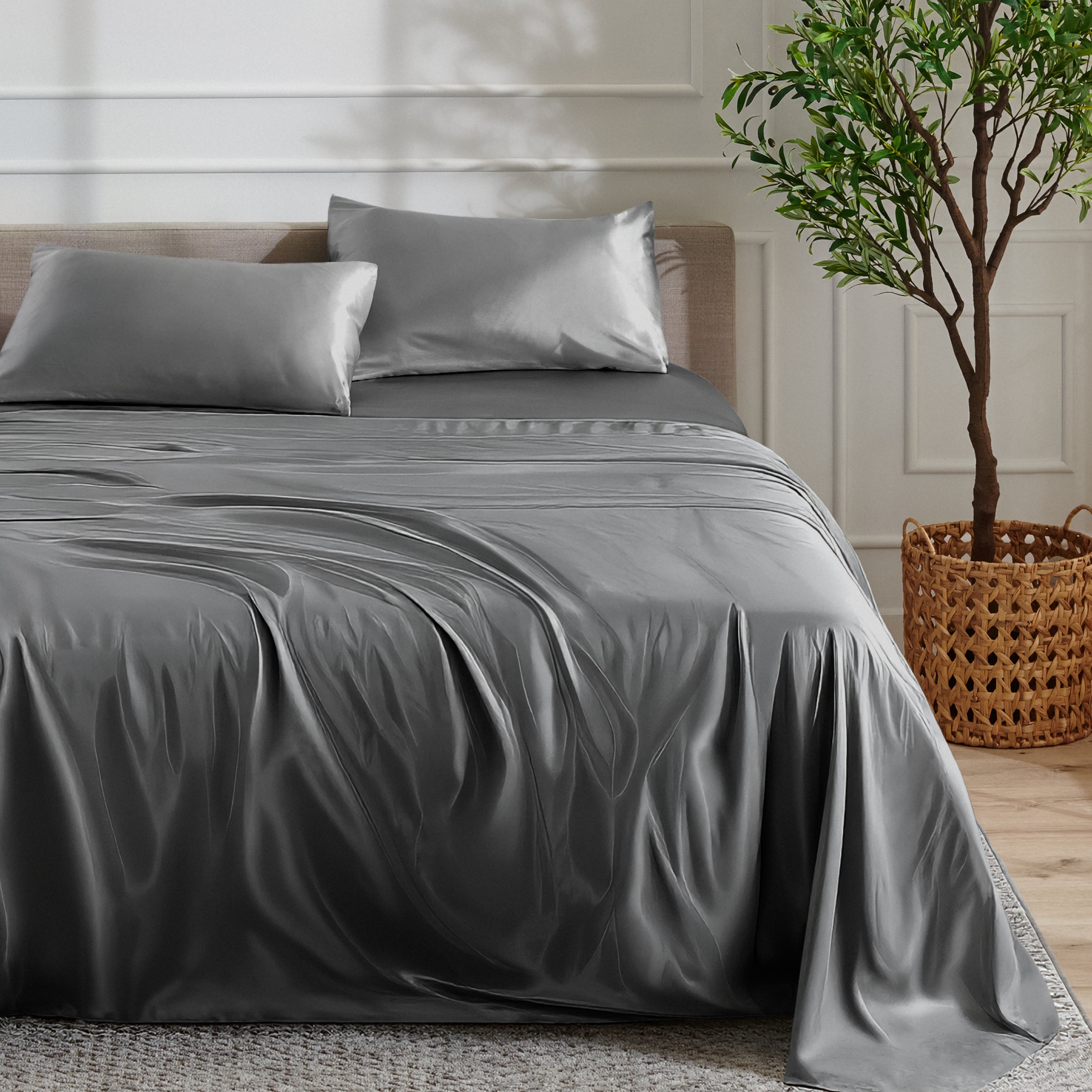 Satin sheet set on a bed with a plant and basket in the background
