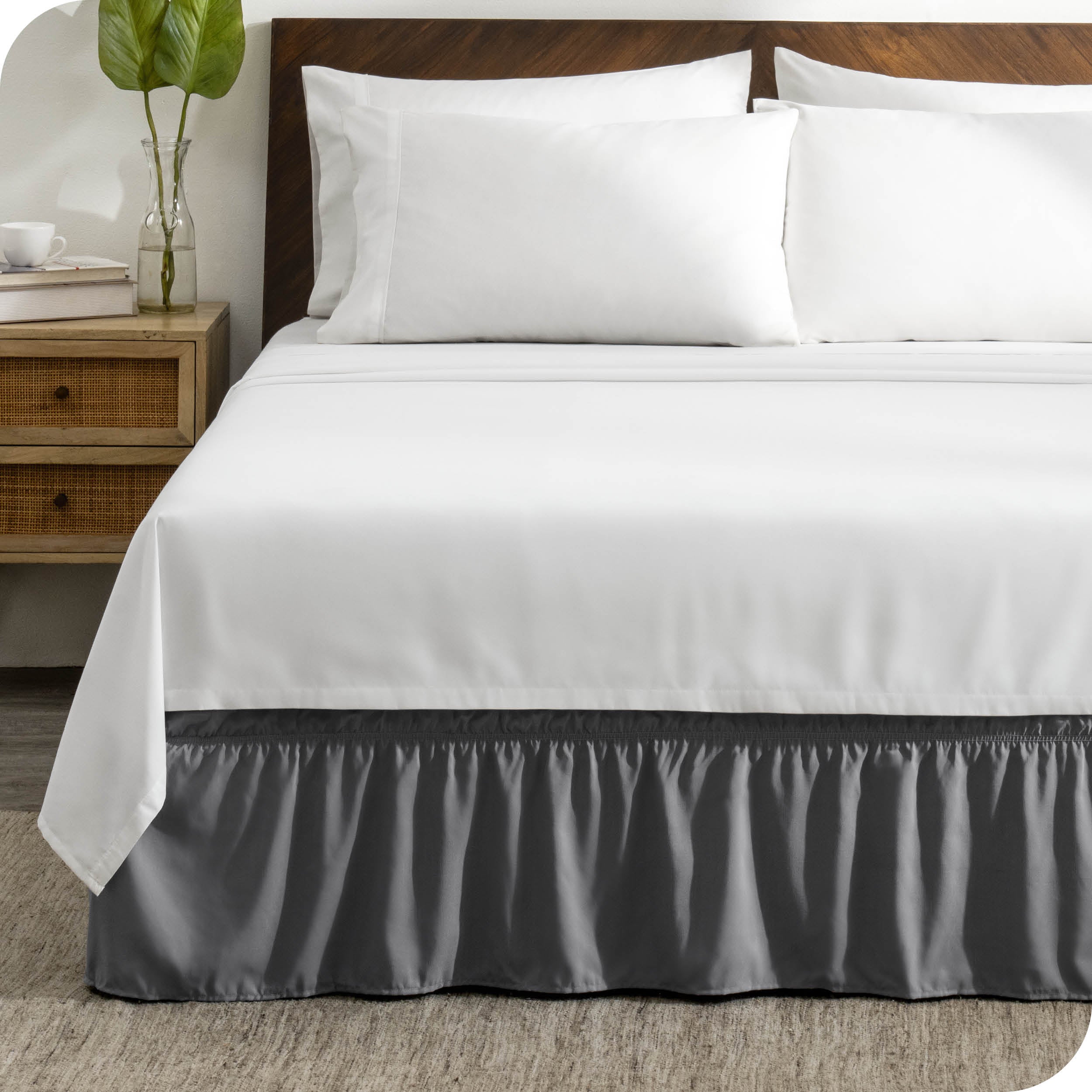 A wrap around bed skirt on a mattress with white bedding
