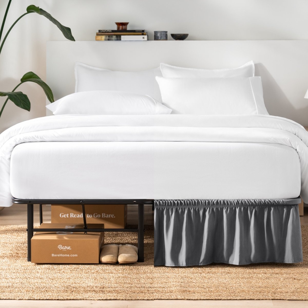 Bed with white bedding and a plant near the bed.