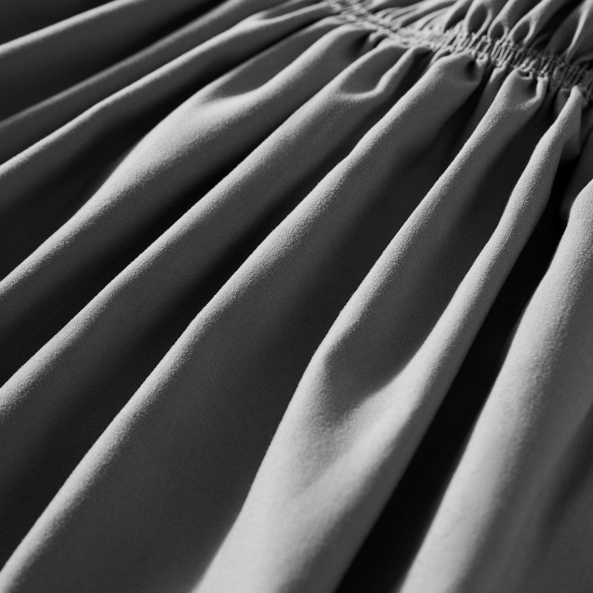 Close-up of polyester bed skirt fabric with a focus on texture and folds.