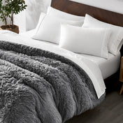 Shaggy duvet cover on a bed with white pillows and a wooden headboard.