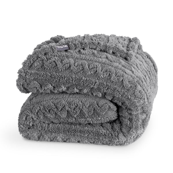 A cable knit sherpa blanket folded neatly