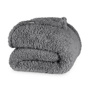 Folded textured blanket with a brand label on a white background