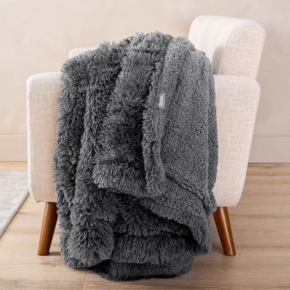 A shaggy blanket draped over the arm of a chair