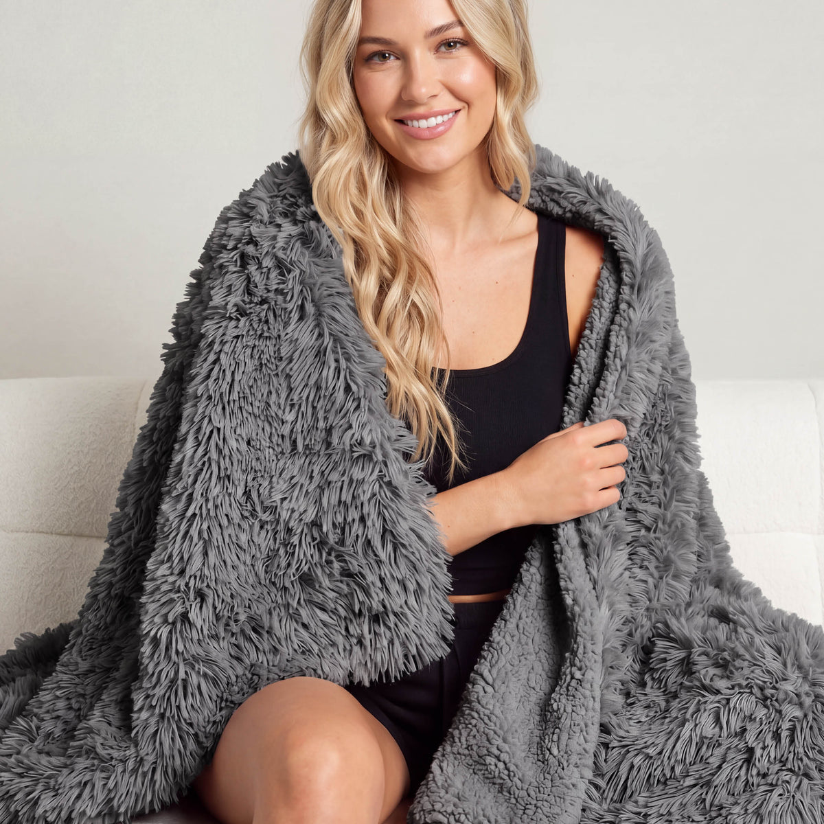 A woman sitting with a shaggy blanket wrapped around her