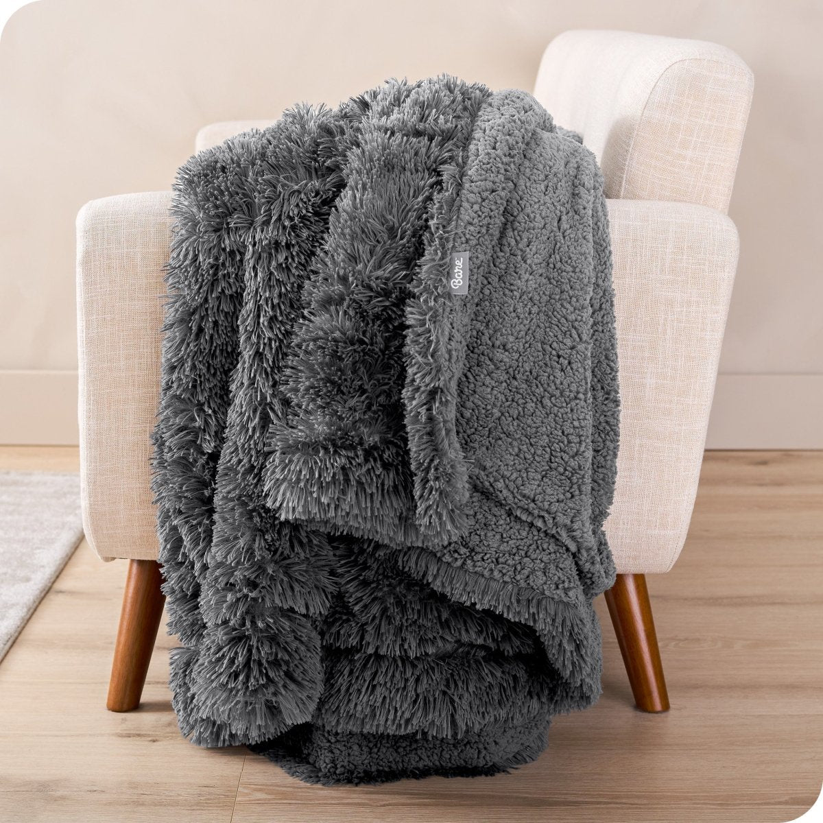 A shaggy faux fur blanket draped over the arm of a chair