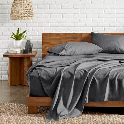 Bedroom with wooden bed, nightstand, and white brick wall.