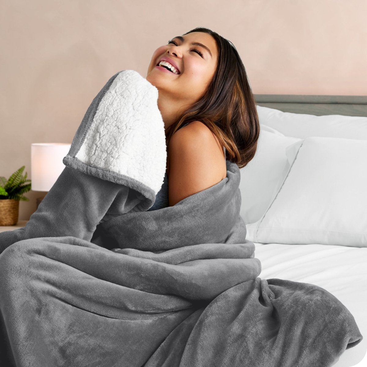 A woman smiling while wrapped in a sherpa blanket