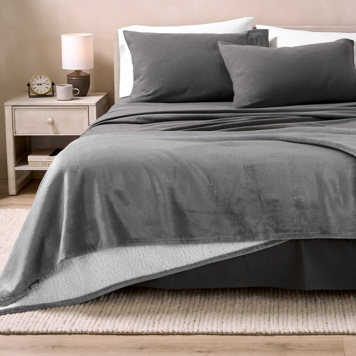 Bed with grey sheets and a sherpa blanket