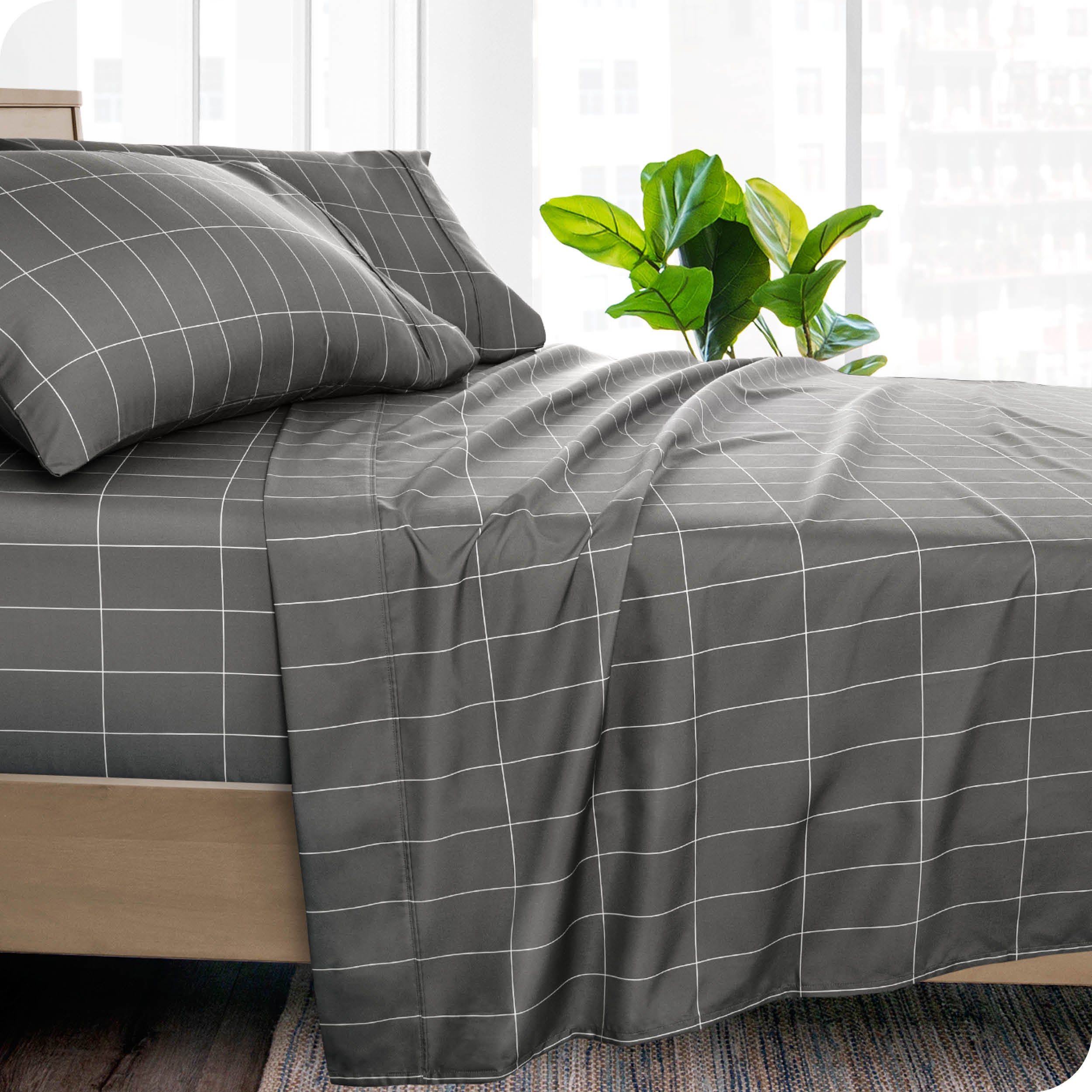 Side view of a bed made with grey and white grid print sheets
