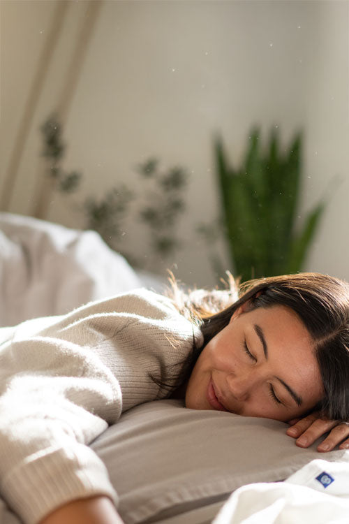 woman laying on a bed with her arm falling off the edge of the bed