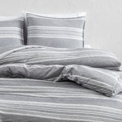 Gray striped bedding set on a bed with a white background