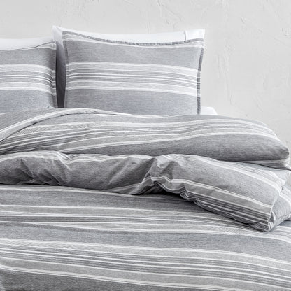Gray striped bedding set on a bed with a white background