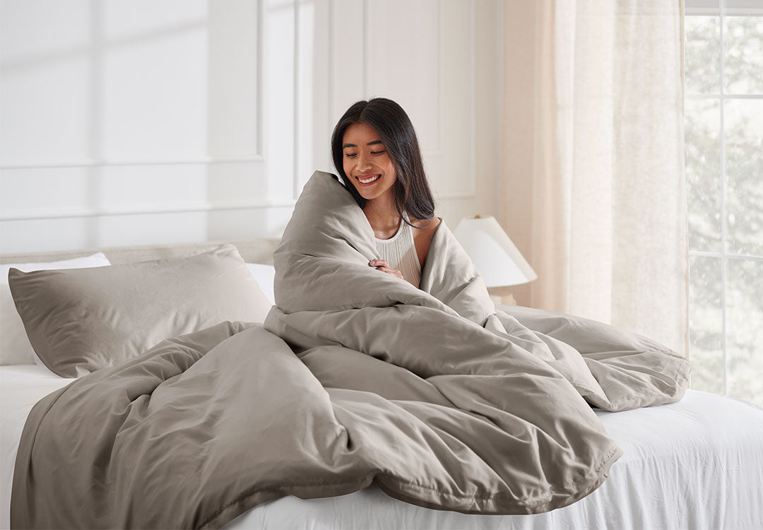 Woman Sitting on bed with beige microfiber sheets