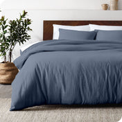 Relaxing room scene showing a indigo linen duvet cover set laid out over the bed