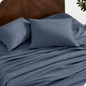 Close up of linen sheet set on a mattress with pillows inside the pillowcases