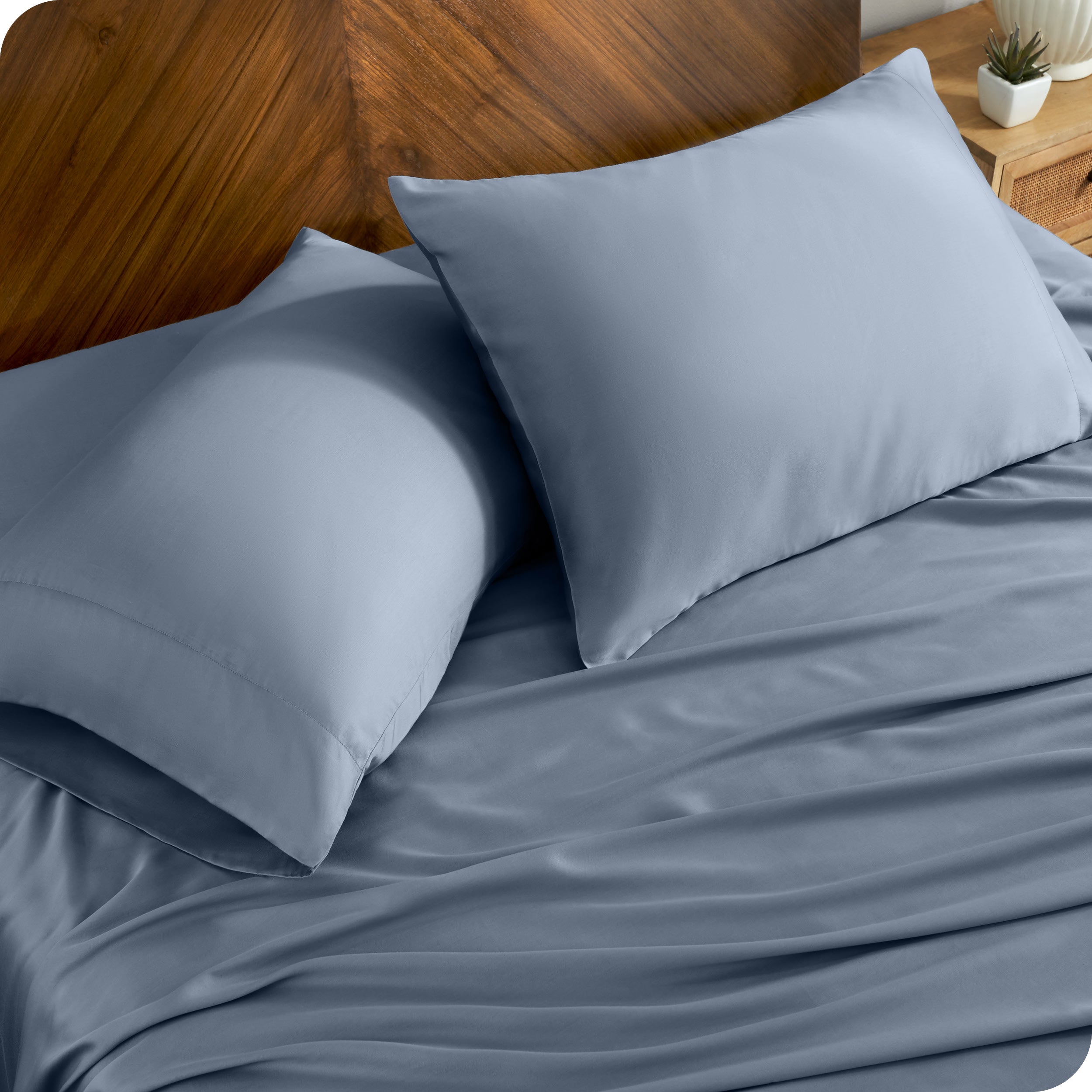TENCEL™ pillowcases on pillows near a wooden headboard