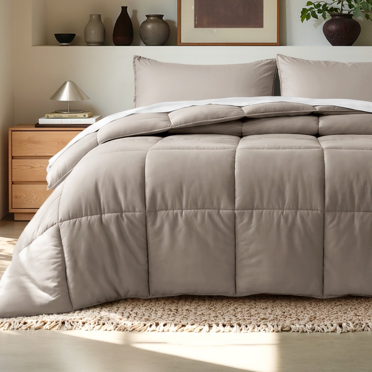 Comforter on a bed in a bedroom setting with a wooden nightstand and decorative items.