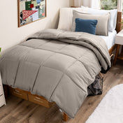 Bed with comforter and pillows in a dorm room