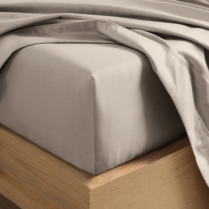 Close up of the corner of a mattress with a fitted sheet and flat sheet on it