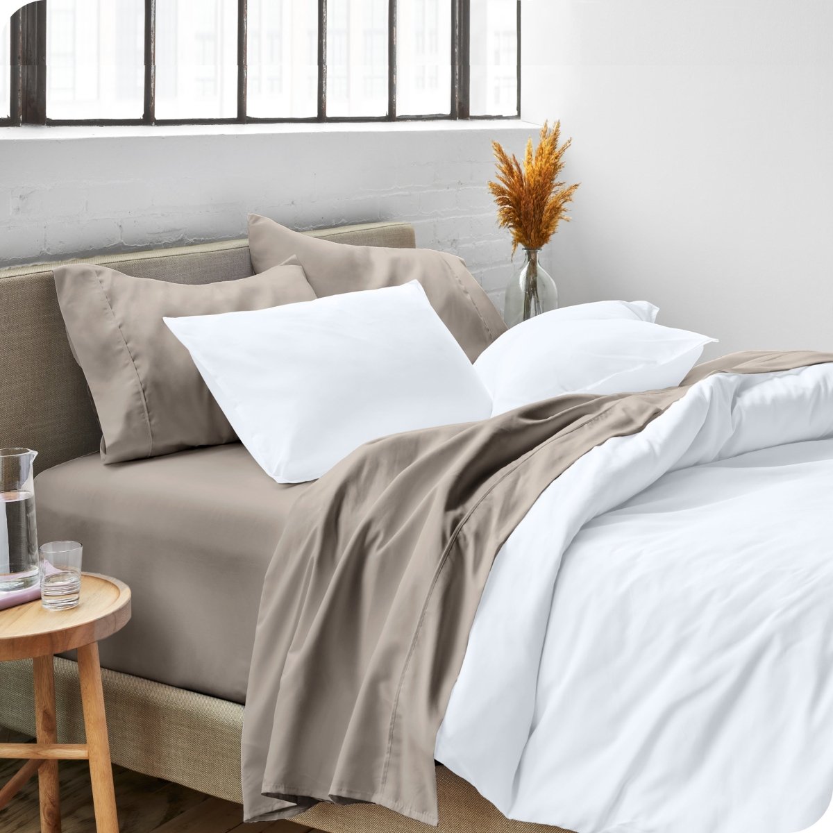 A side view of a bed made with microfiber sheets and a white duvet cover