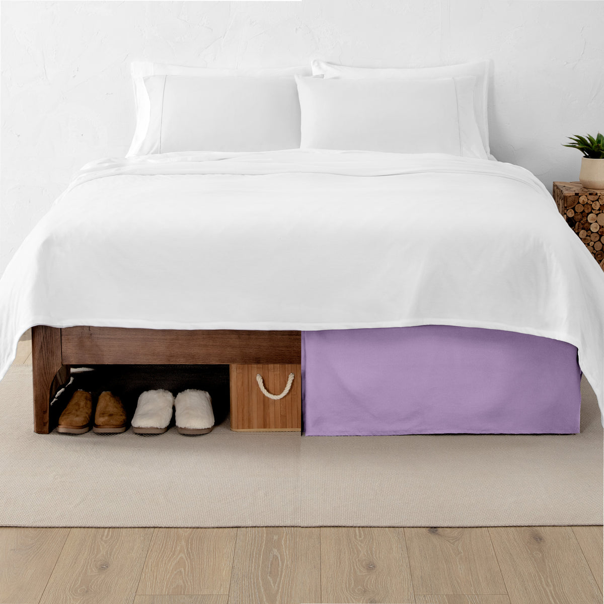 One side of a bed has shoes and a box under it while the other side has a bed skirt so that under the bed is hidden from view