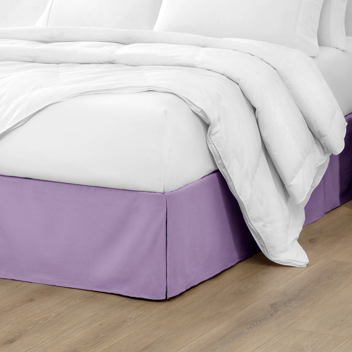 Microfiber bed skirt on a bed with white bedding and wooden floor.