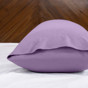 Body pillowcase with an envelope closure on a bed with a wooden headboard