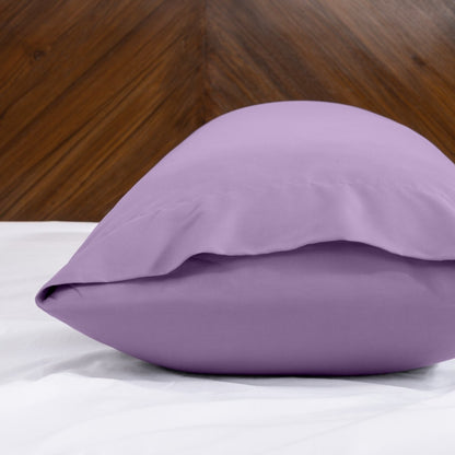 Body pillowcase with an envelope closure on a bed with a wooden headboard