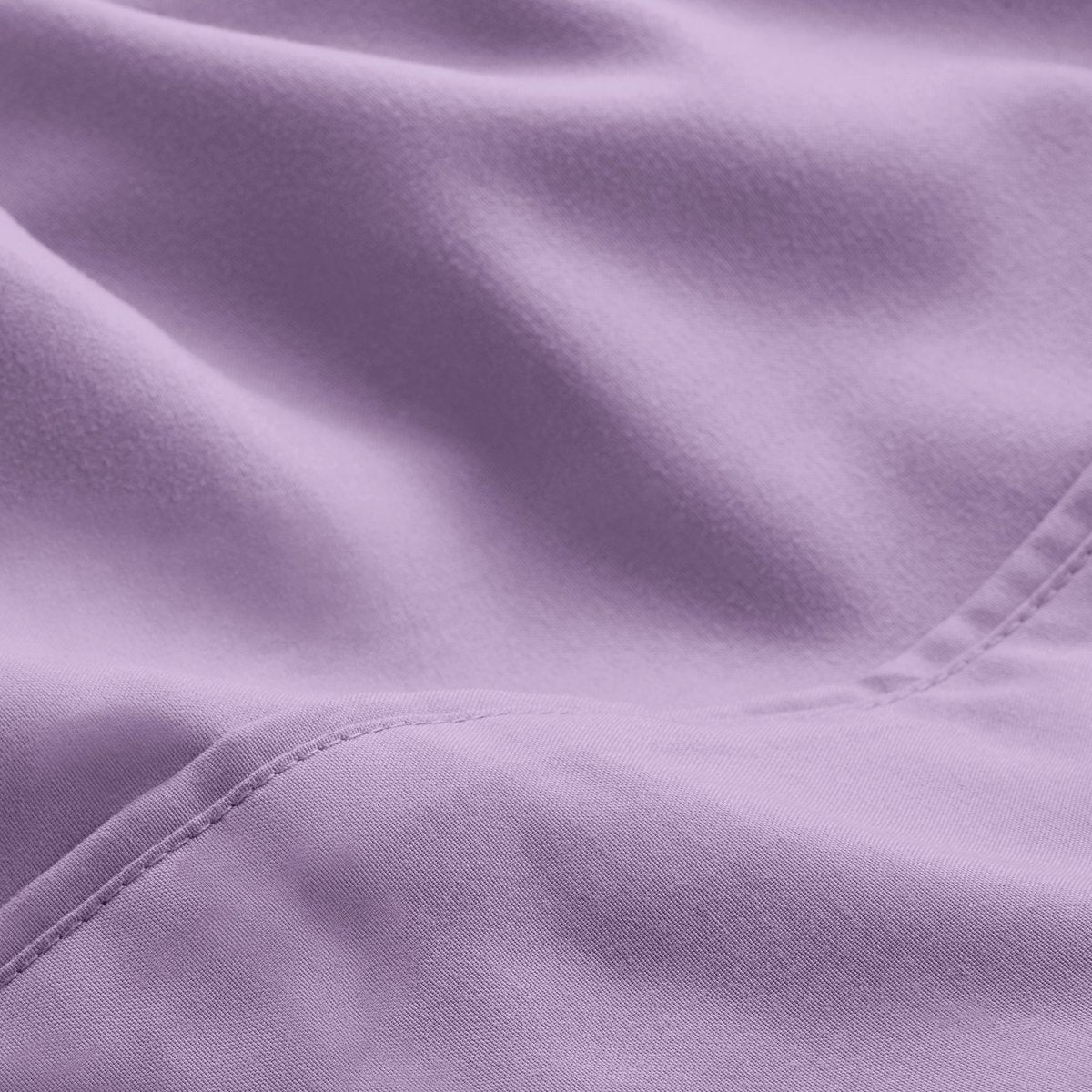 A close-up of microfiber fabric with soft folds and a visible stitched seam.