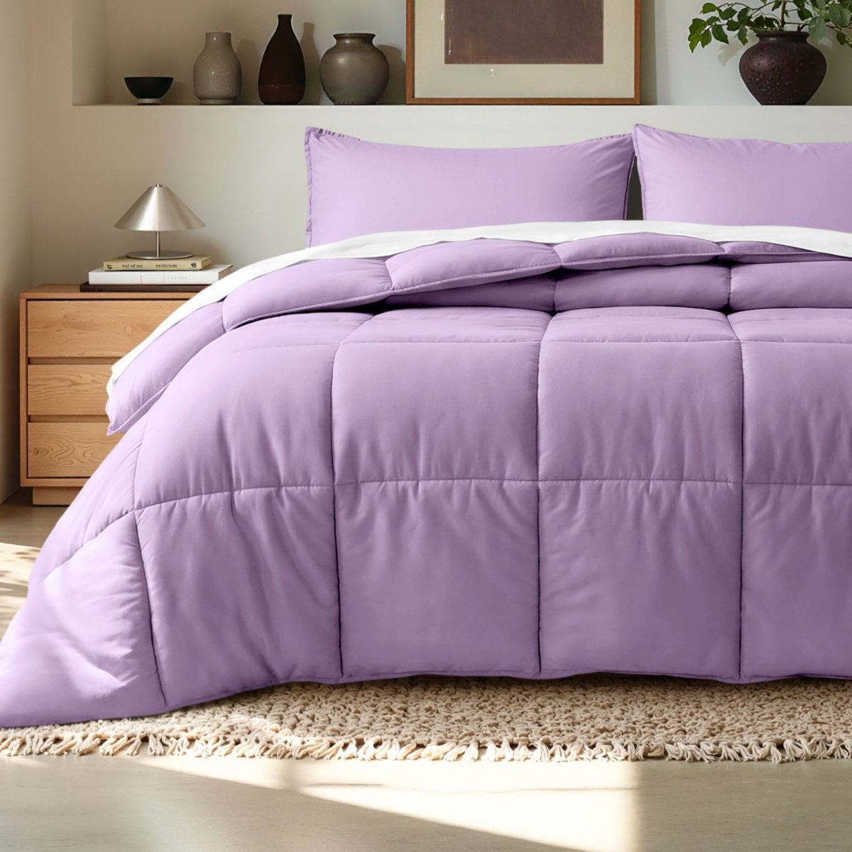 Comforter on a bed in a bedroom setting with a wooden nightstand and decorative items.