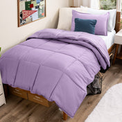Bed with comforter and pillows in a dorm room