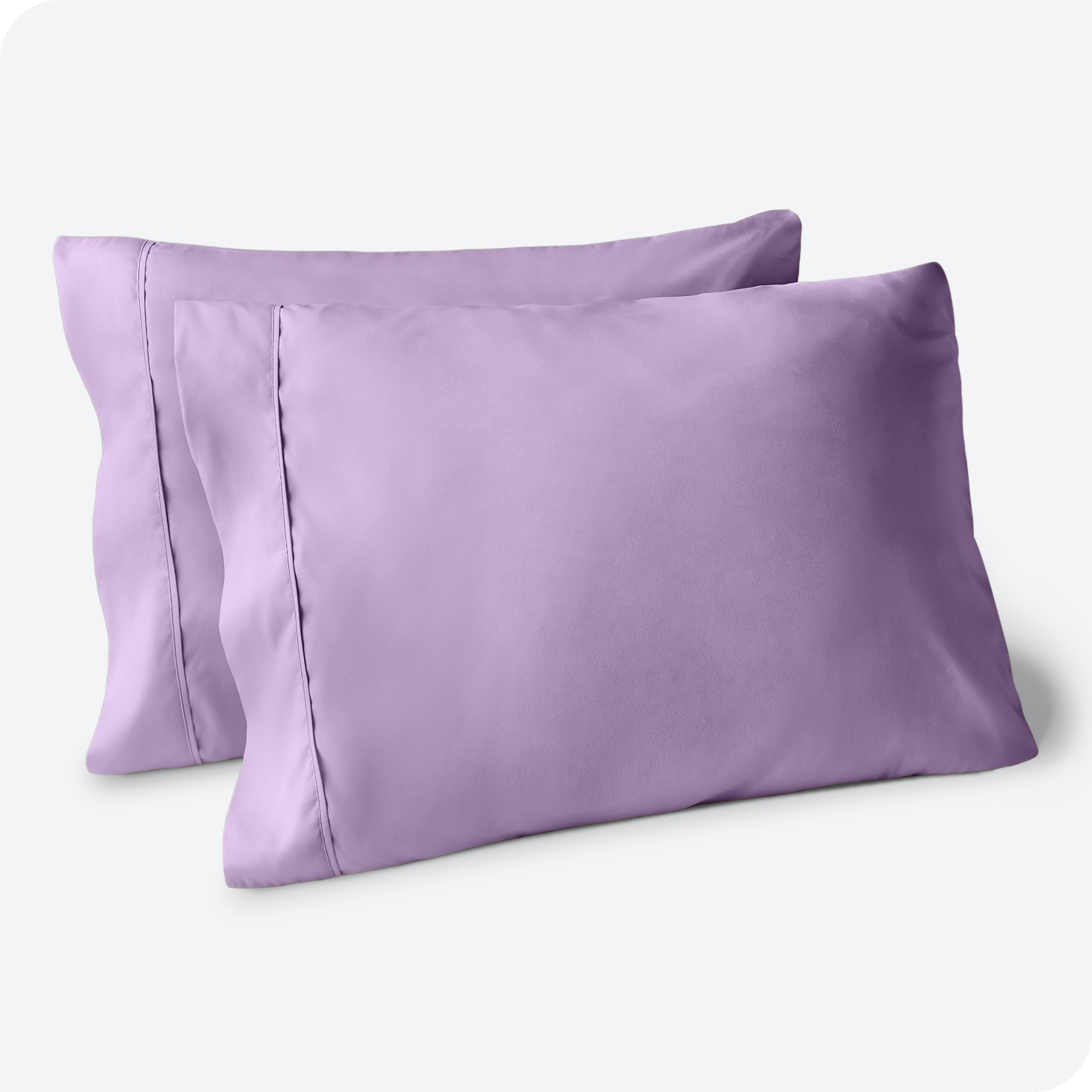 Two pillows on a white background with purple pillowcases on them