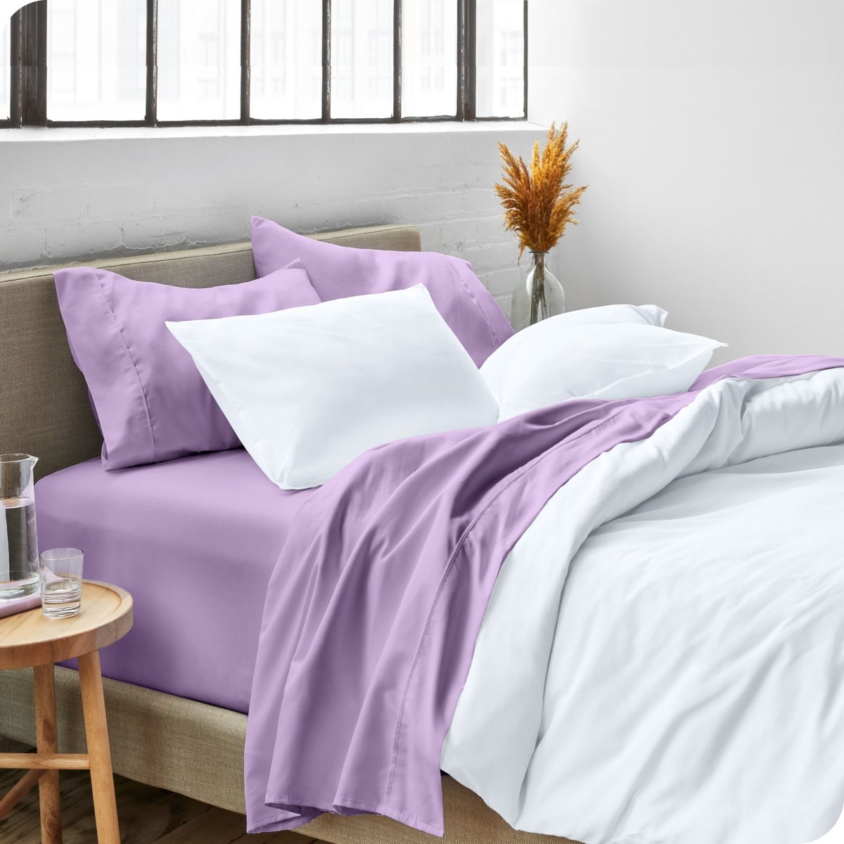 A side view of a bed made with microfiber sheets and a white duvet cover