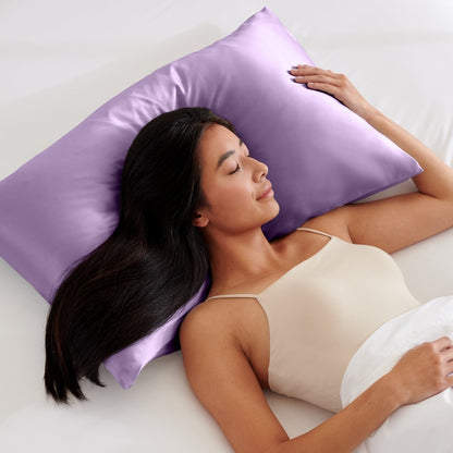 Woman lying on a bed with a pillow covered with a satin pillowcase