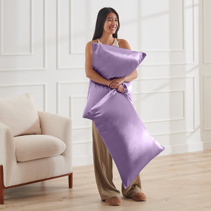 Woman holding 2 pillows with satin pillowcases on them