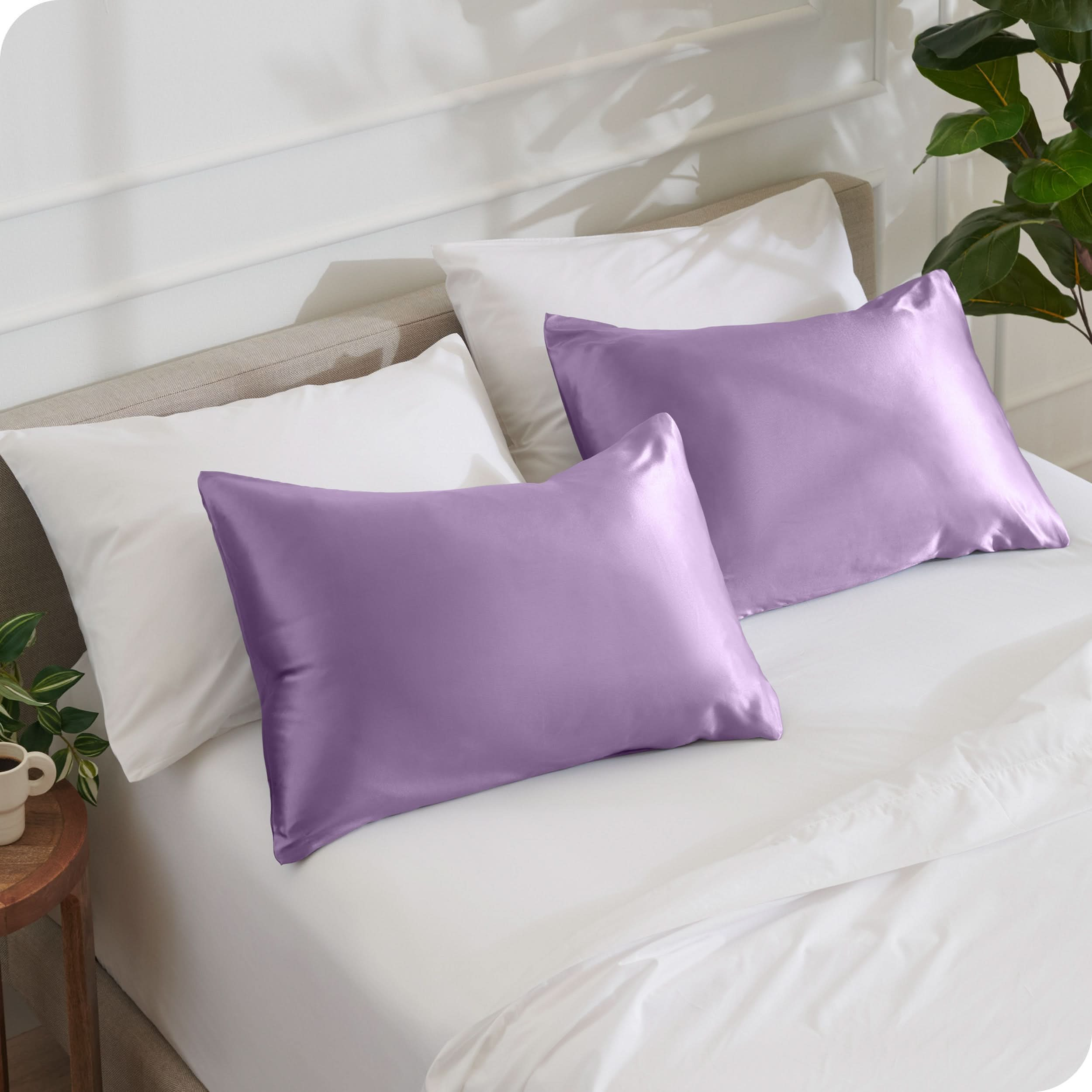 2 satin pillowcases on pillows set on a bed