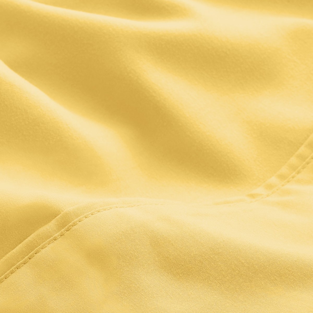 A close-up of microfiber fabric with soft folds and a visible stitched seam.