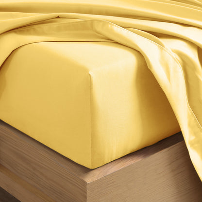 Close up of the corner of a mattress with a fitted sheet and flat sheet on it