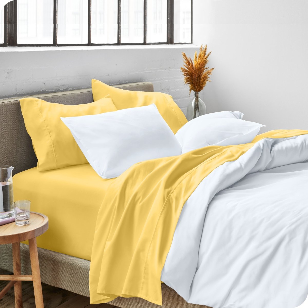 A side view of a bed made with microfiber sheets and a white duvet cover