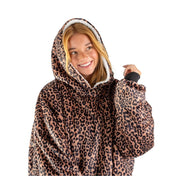 An adult with a hooded wearable blanket on