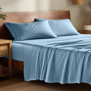 Bamboo bed sheets on a bed in a bedroom with night stands.